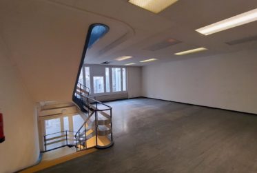 Bâtiment commercial/administratif brut avec arcade au cœur de la ville